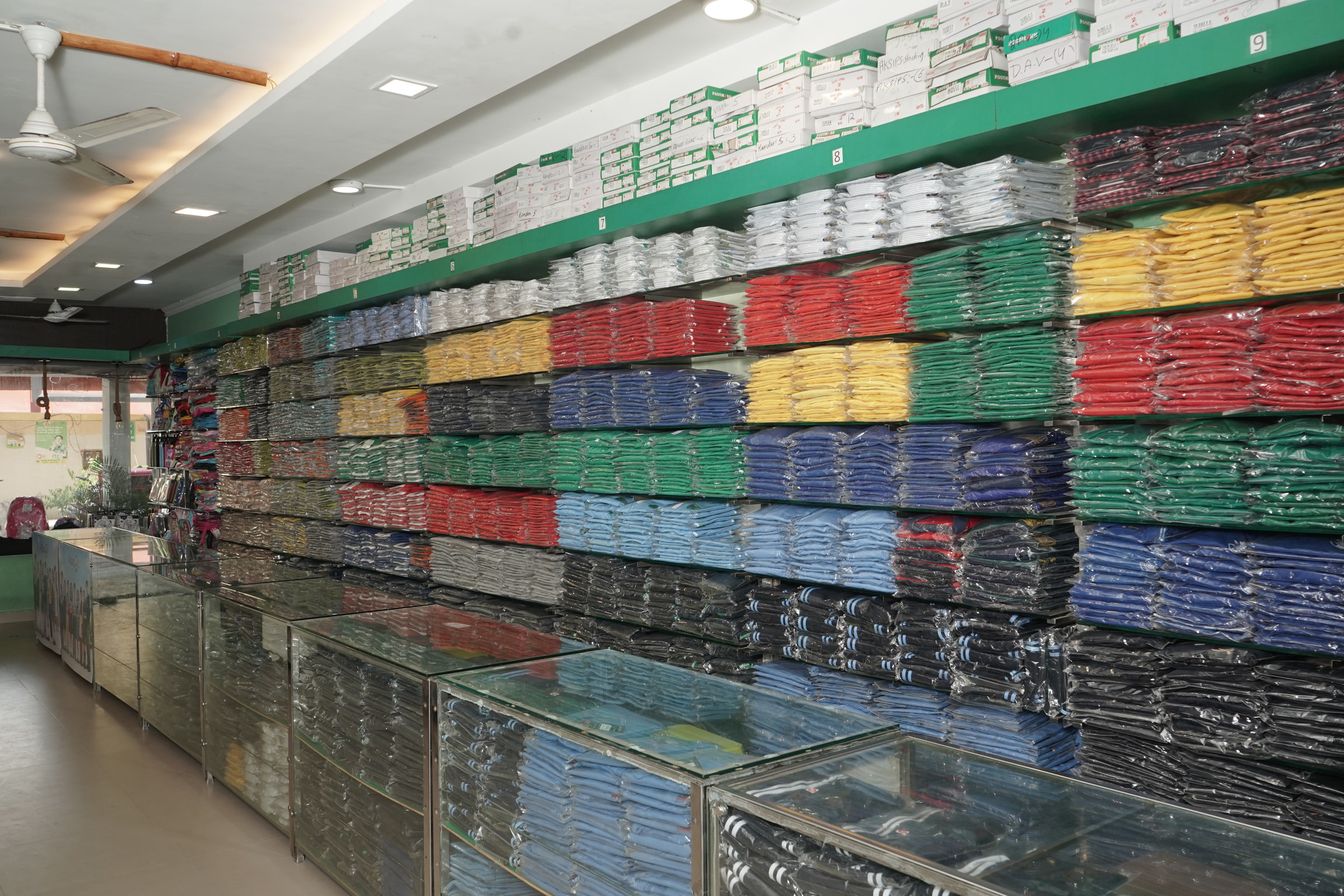 Colour-blocked house shirts above the glass counter at Mohali
